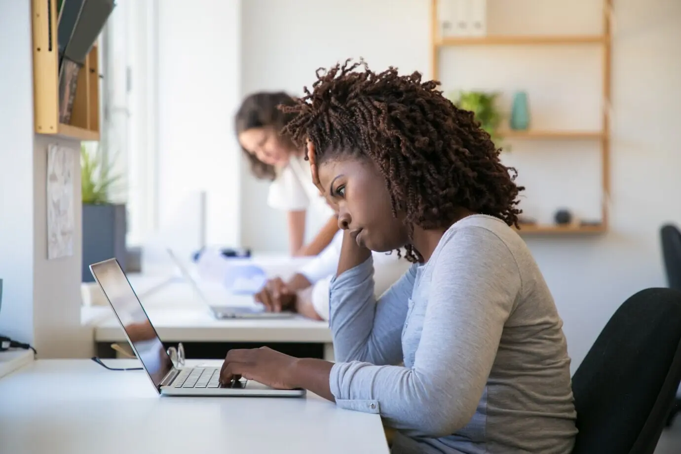 Müde afroamerikanische angestellte Person, die an einem Projekt arbeitet.